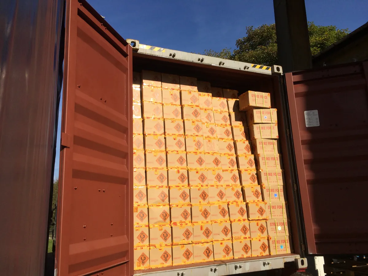 Container vol kartons met het gevaarsetiket 1.3G, vuurwerk als gevaarlijke stof van klasse 1