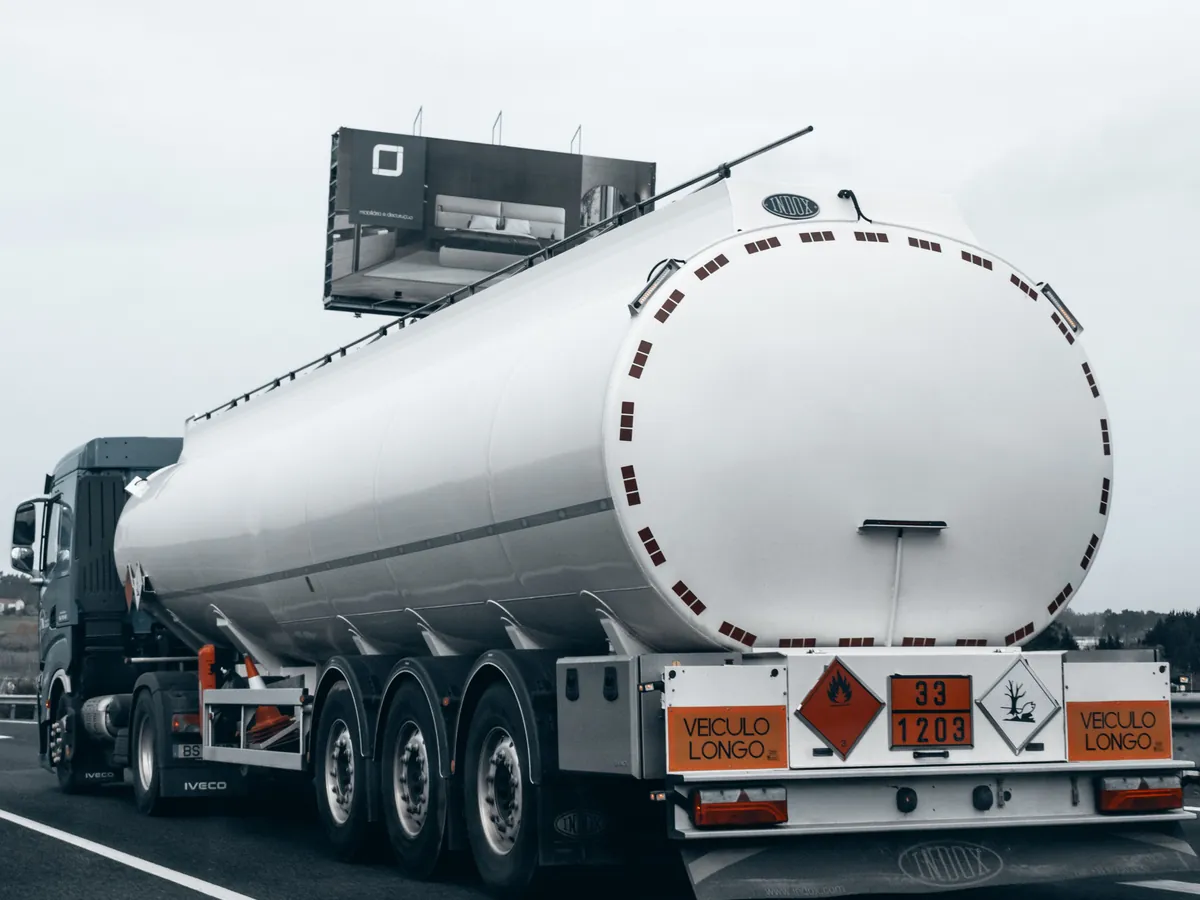 Achterkant van een tankoplegger met het oranje bord 33/1203 voor benzine en het gevaarsetiket van klasse 3