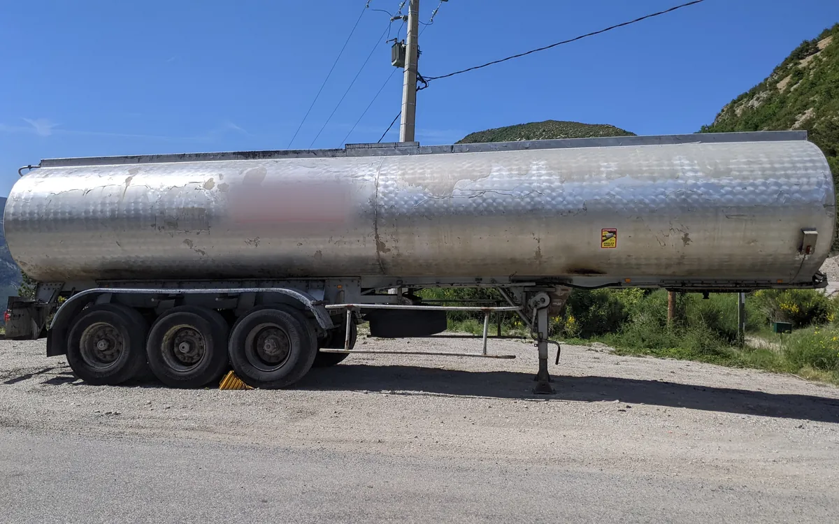 Stainless steel tank semi-trailer parked at a mountain pass in France