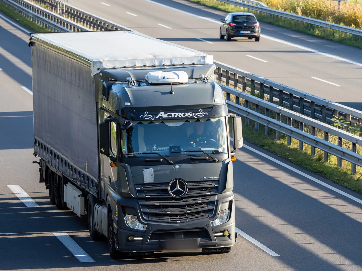 Mercedes-Benz Actros with a curtainsider semi-trailer on a German autobahn, a full load on the road