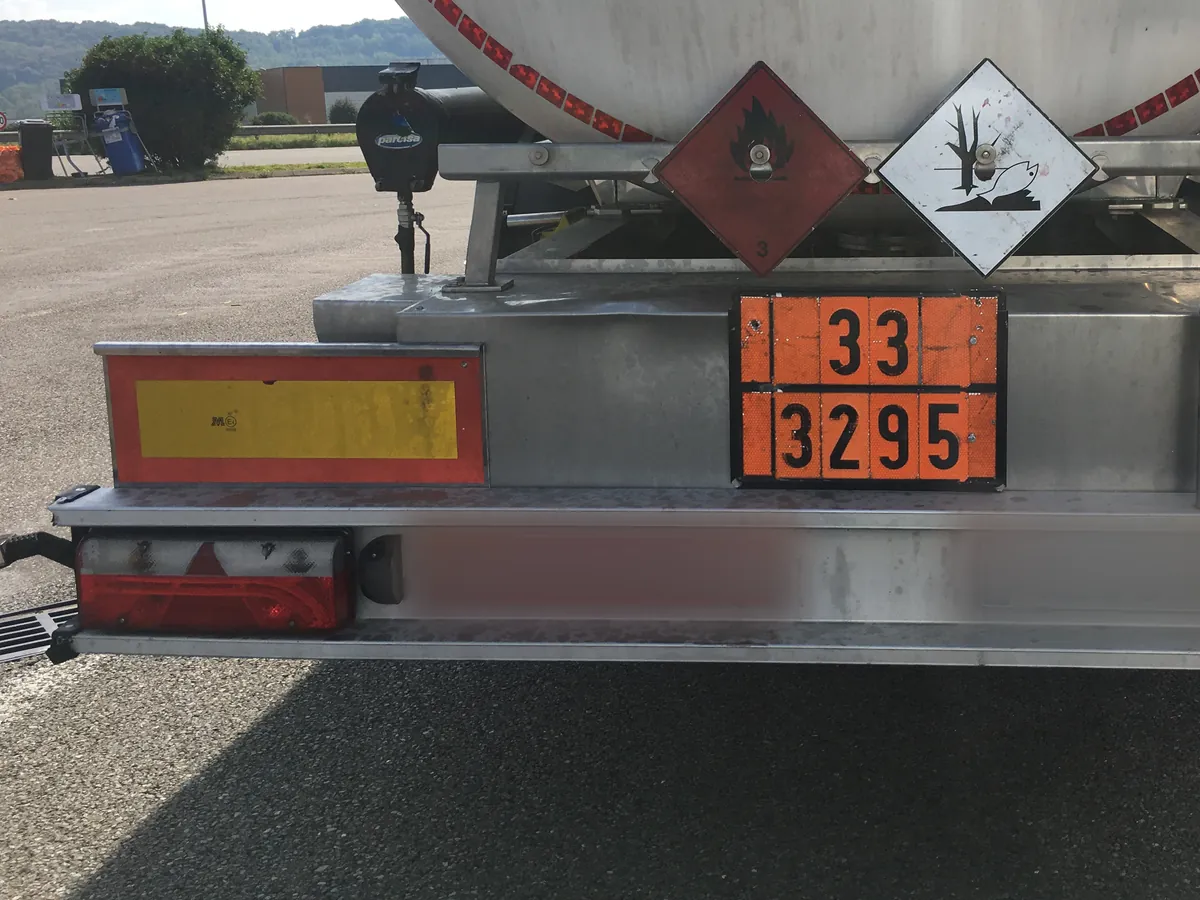 Orangefarbene Warntafel mit der Gefahrnummer 33 über der UN-Nummer 3295 am Heck eines Tankaufliegers