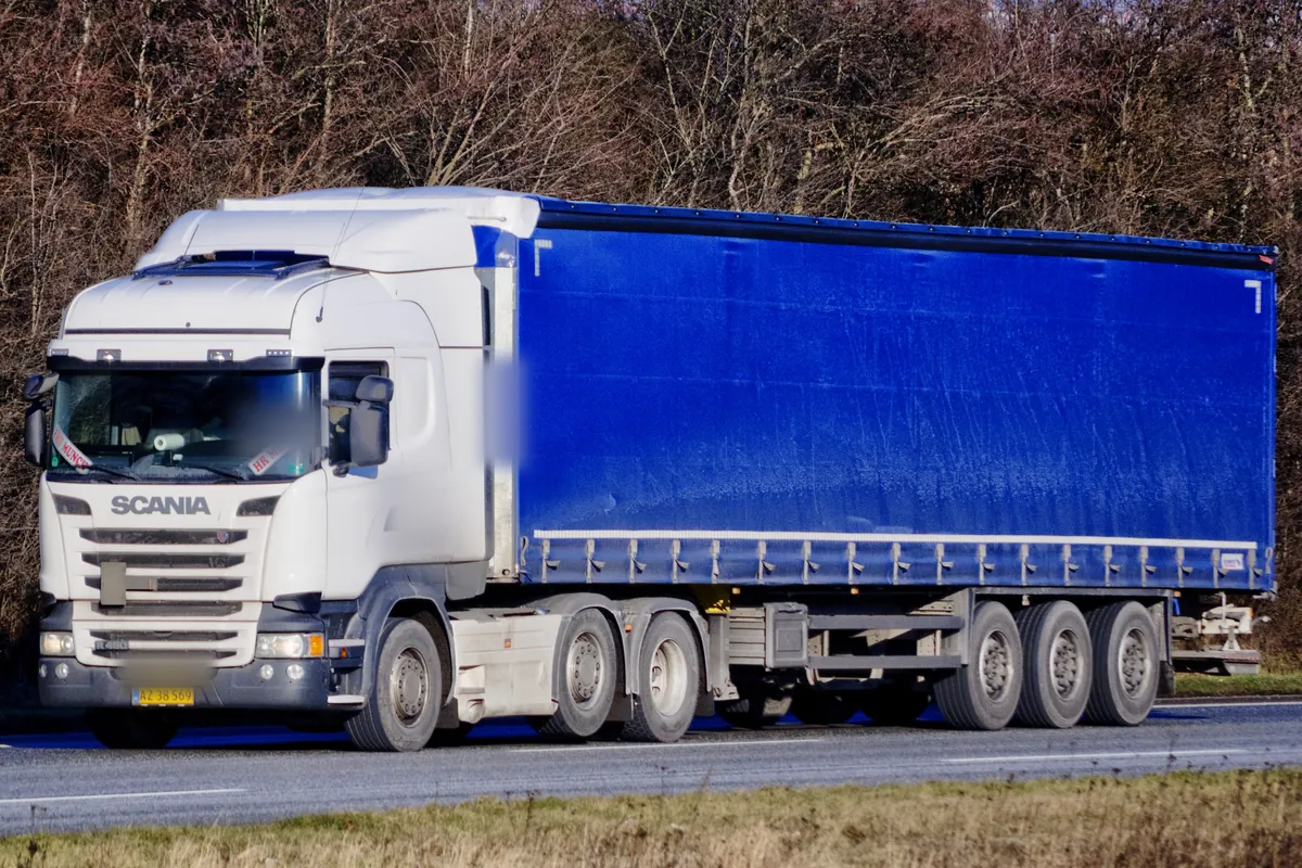 Scania tractor with a blue curtainsider semi-trailer, the kind of trailer part loads share