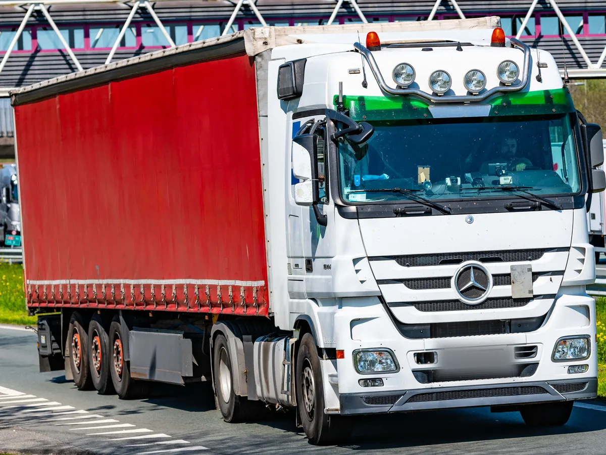 Lorry with a red curtainsider on the A16 near Zwijndrecht in the Netherlands