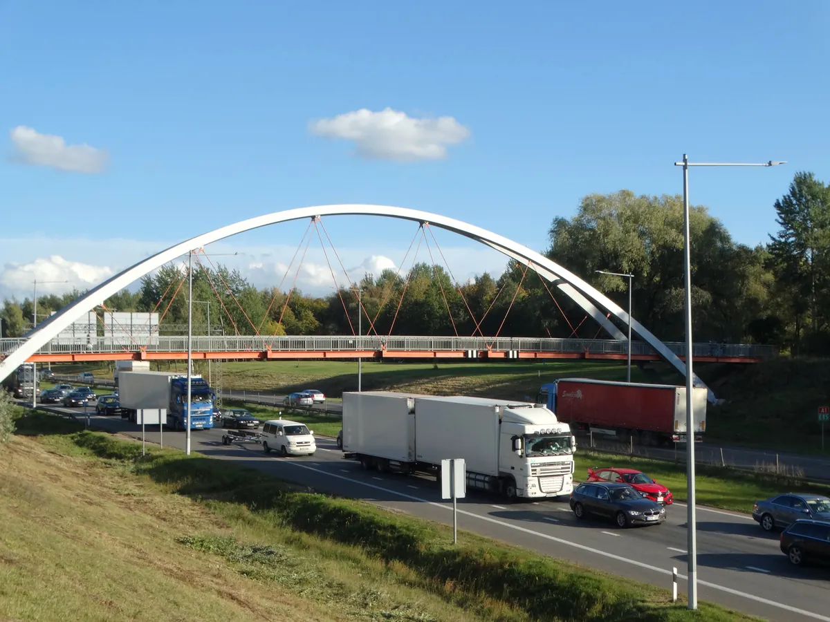 Lkw auf der Autobahn A1 bei Kaunas unter der Bogenbrücke von Kleboniškis in Litauen