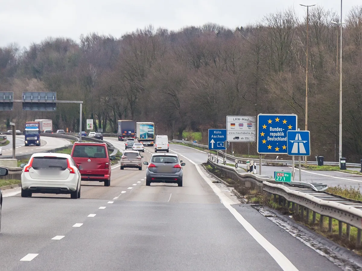 Grensovergang van de A76 naar de Duitse A4, met het bord Bundesrepublik Deutschland en vrachtwagens richting Duitsland