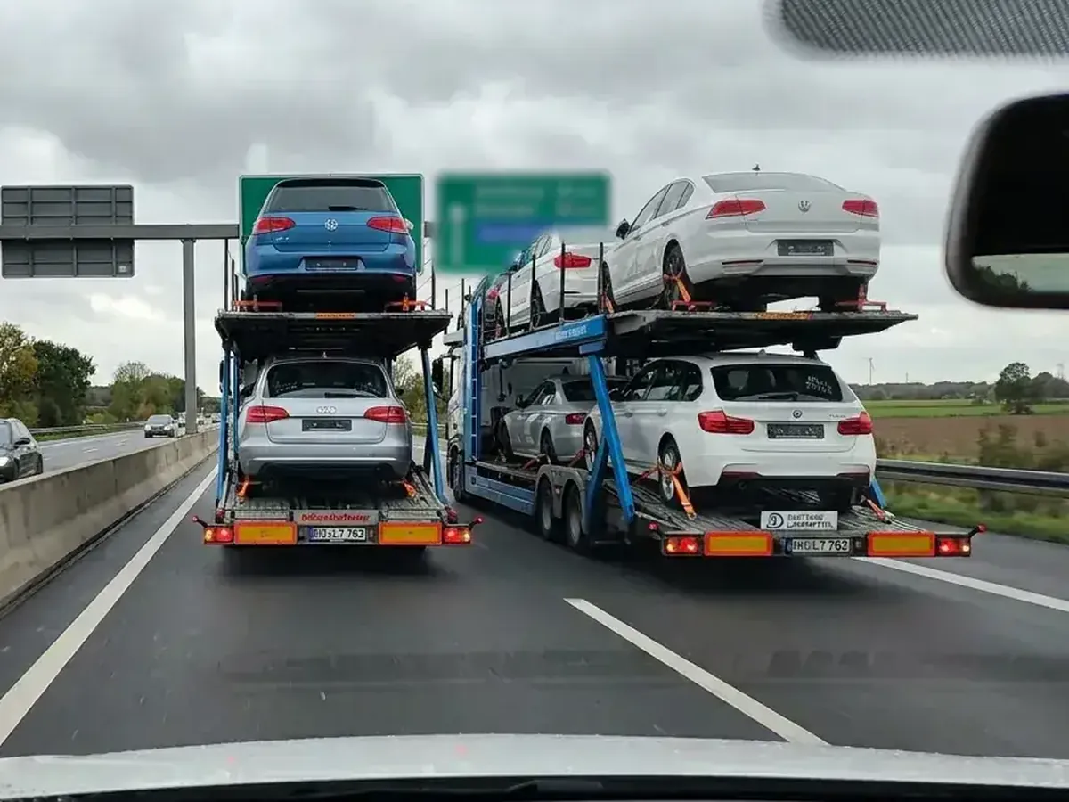 Two loaded car transporters on a motorway, the vehicle corridor from Germany to Belgium
