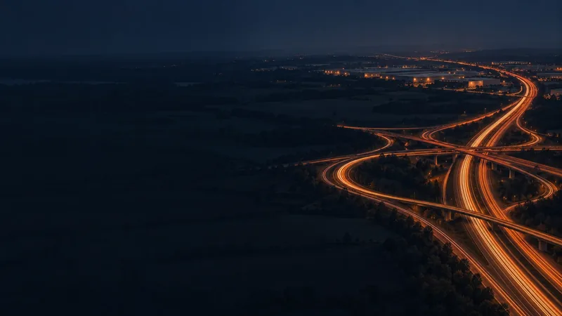 Light trails of night traffic on a motorway interchange, seen from above